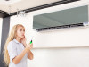 Woman looks at a broken air conditioner